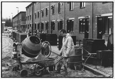 351539 Afbeelding van een bouwvakker met een kruiwagen bij een cementmolen in de nieuwbouwwijk Galecop te Nieuwegein.